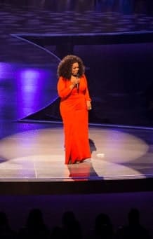 Oprah Winfrey speaks on stage at a live event.