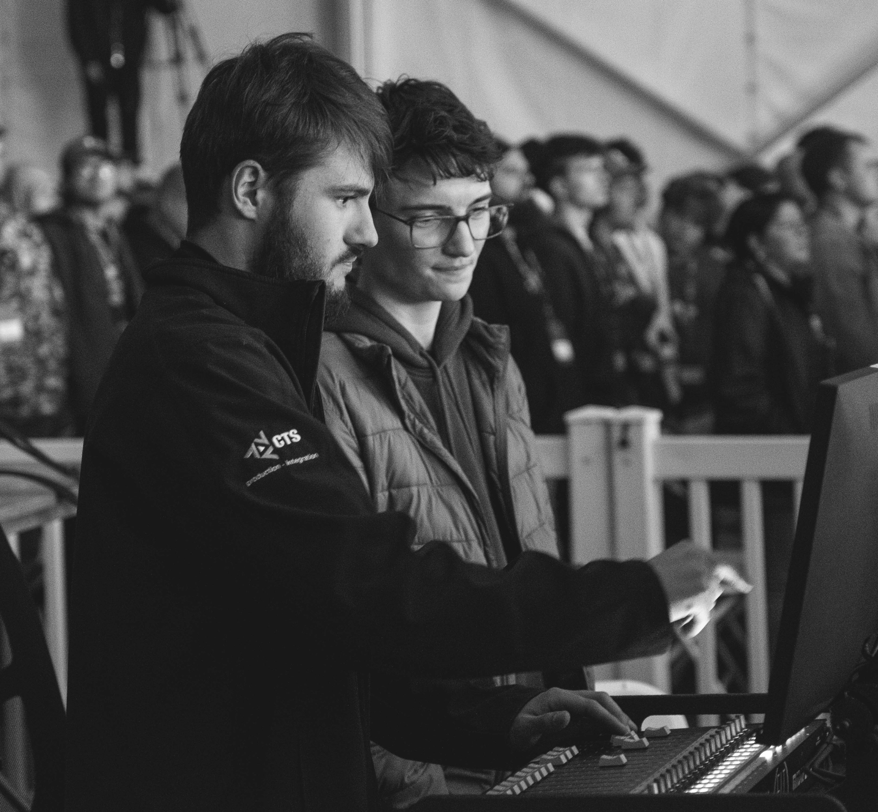 audio engineer using a console at a live event and instructing another technician
